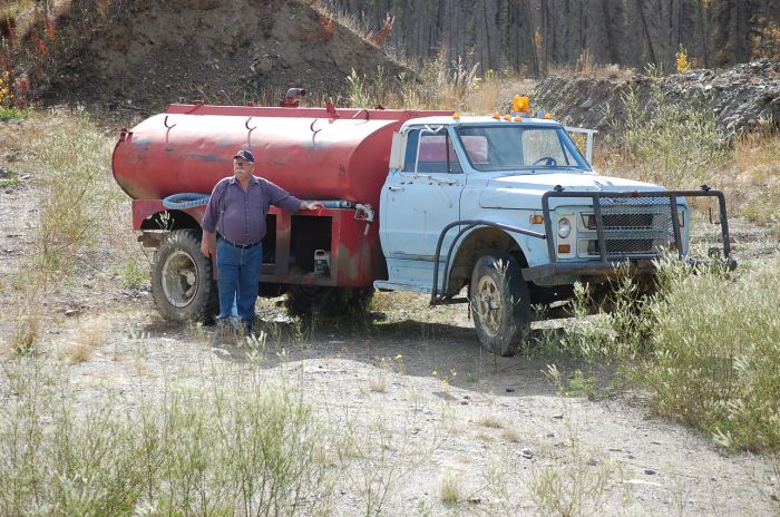 Deputy Chief Taylor, our Museum Curator, stands by the truck to which the tank is now attached, on an old mining claim